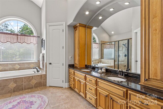 bathroom with double vanity, decorative columns, tile patterned flooring, lofted ceiling, and separate shower and tub