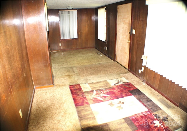 hallway featuring wooden walls