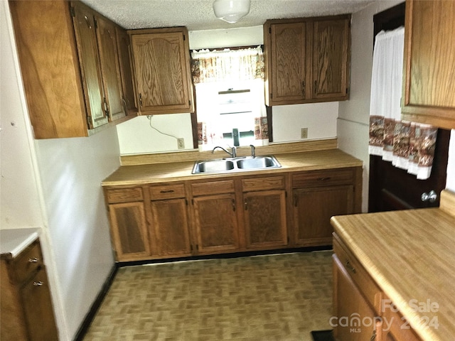 kitchen featuring sink and a textured ceiling