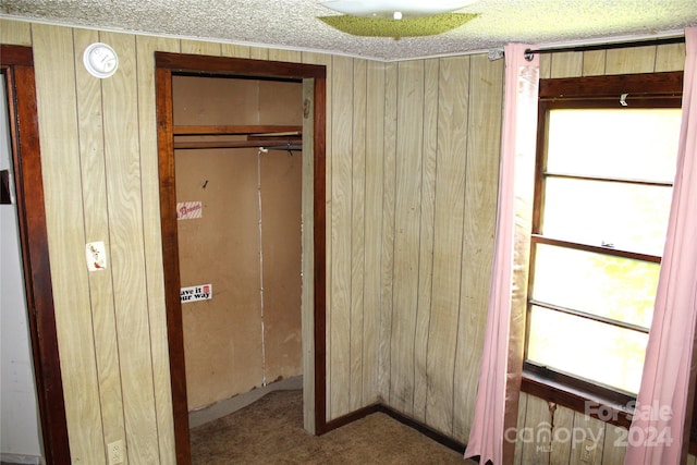 unfurnished bedroom featuring a closet and wood walls