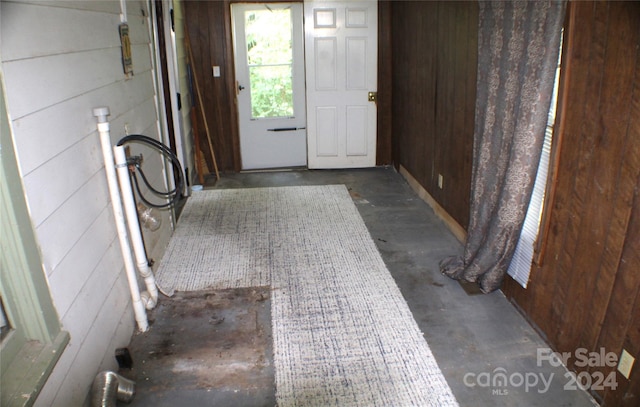 doorway featuring wooden walls