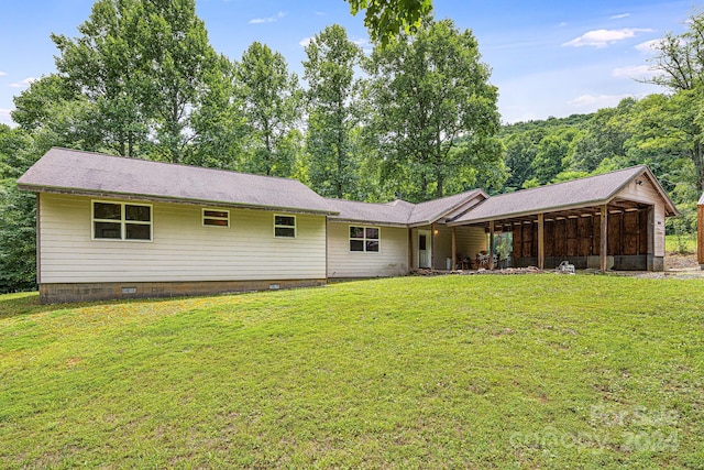 rear view of property featuring a yard