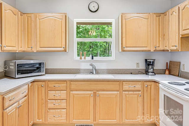 kitchen featuring white range with electric cooktop, sink, and light brown cabinets