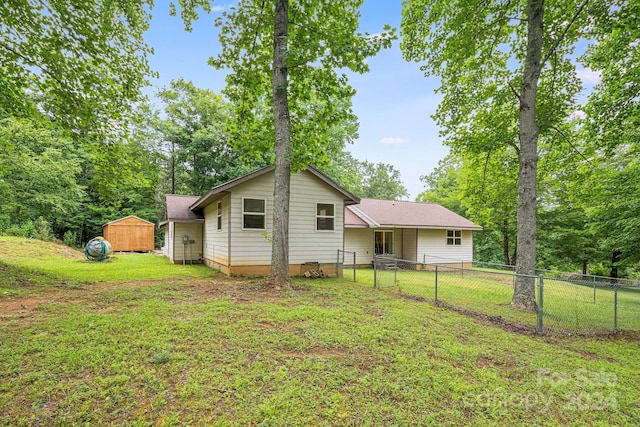 back of property with a storage unit and a lawn