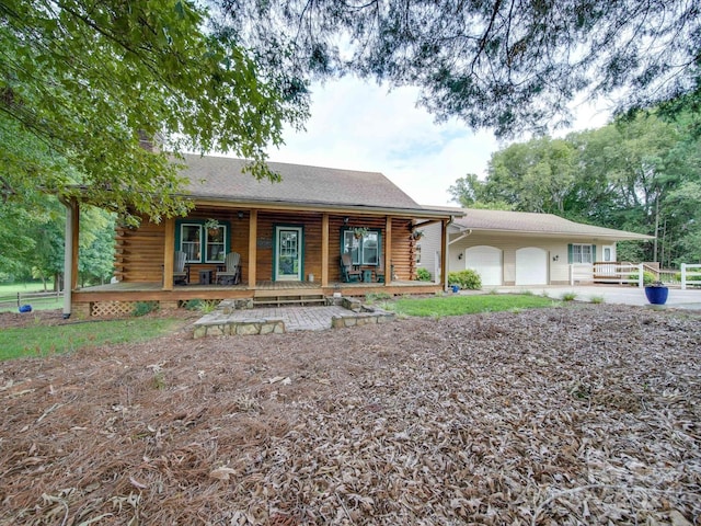 cabin featuring a porch and a garage