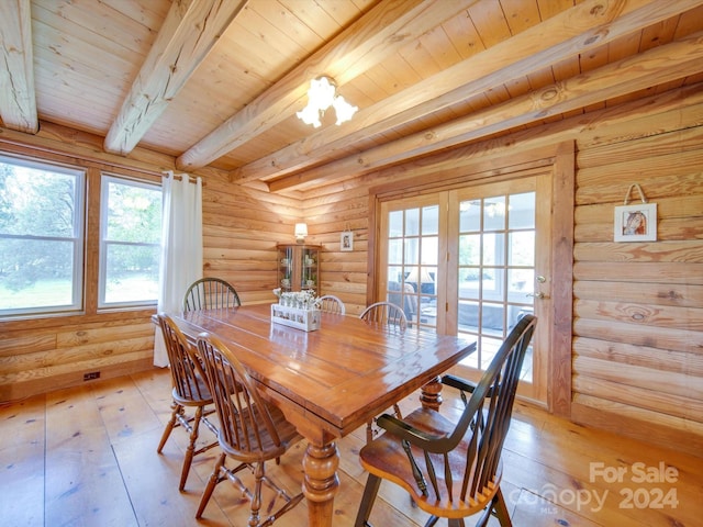 dining room featuring beam ceiling, log walls, light hardwood / wood-style flooring, and wooden ceiling