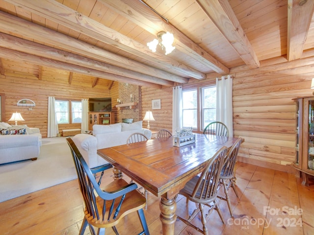 dining area with plenty of natural light, rustic walls, and beam ceiling