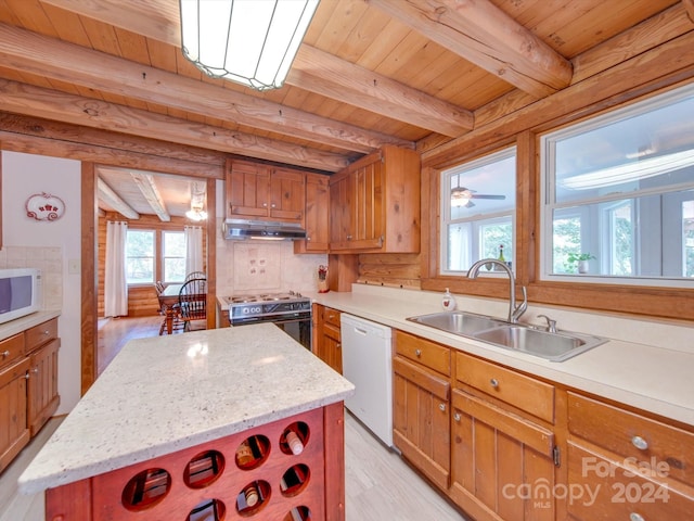 kitchen with white appliances, beam ceiling, a center island, and sink