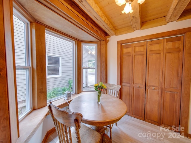 dining area with beam ceiling, light hardwood / wood-style floors, and wooden ceiling