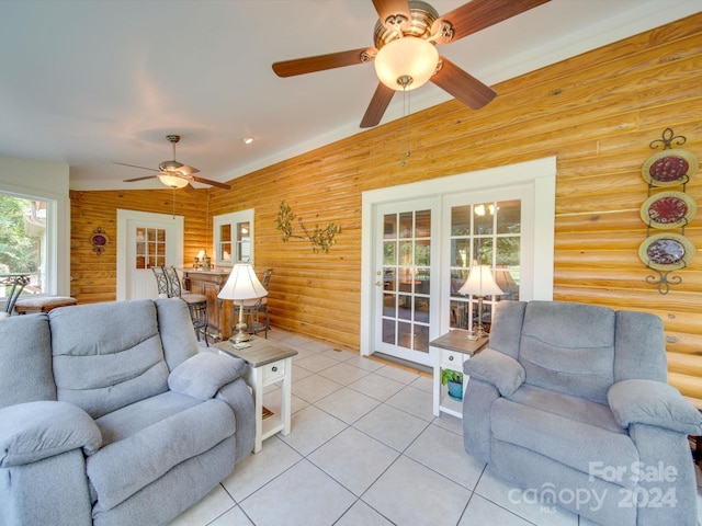 tiled living room featuring french doors, ceiling fan, and log walls