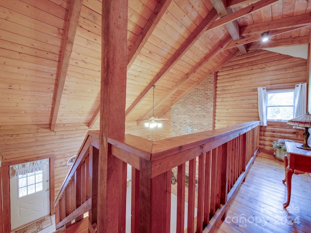 hallway with vaulted ceiling with beams, log walls, light hardwood / wood-style floors, and wood ceiling