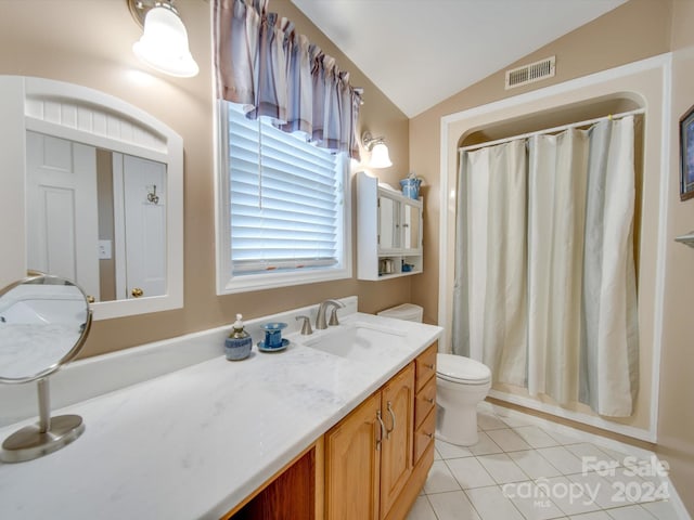 bathroom featuring vanity, vaulted ceiling, tile patterned floors, and toilet