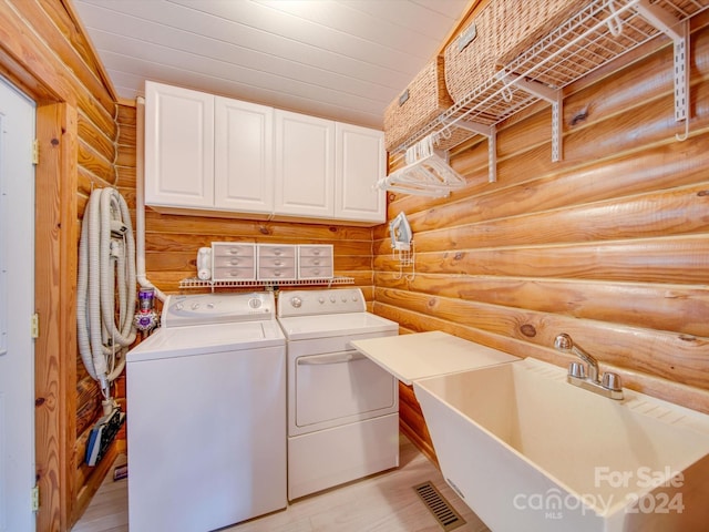 laundry area featuring sink, cabinets, separate washer and dryer, log walls, and wooden ceiling