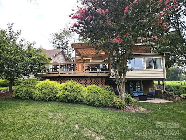 back of property featuring a pergola, outdoor lounge area, a deck, and a lawn