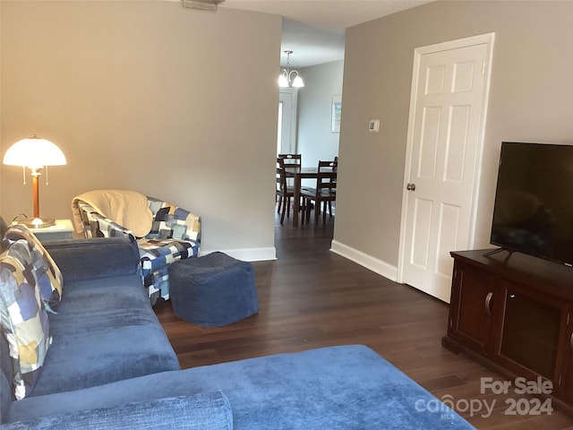 living room with a chandelier and dark hardwood / wood-style floors