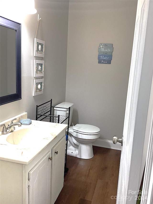 bathroom with vanity, hardwood / wood-style flooring, and toilet