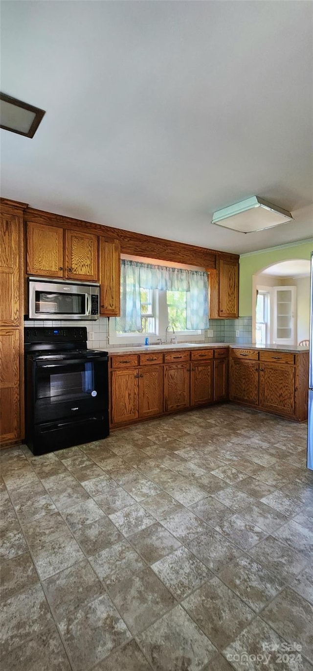 kitchen with a wealth of natural light, stainless steel appliances, and decorative backsplash