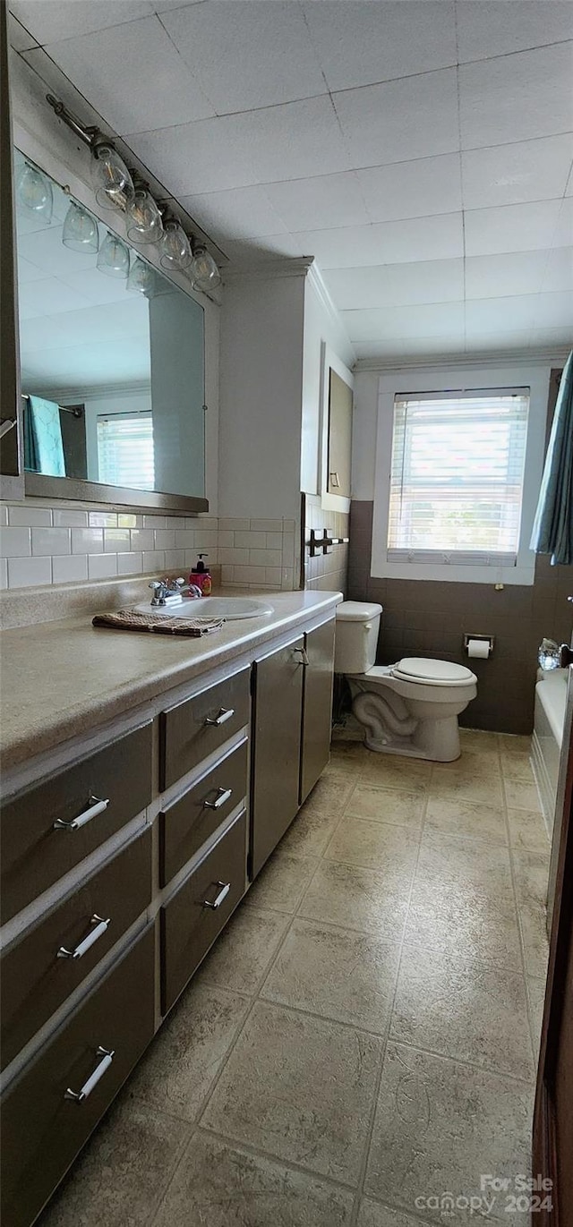 bathroom featuring vanity, tile patterned flooring, toilet, decorative backsplash, and a washtub