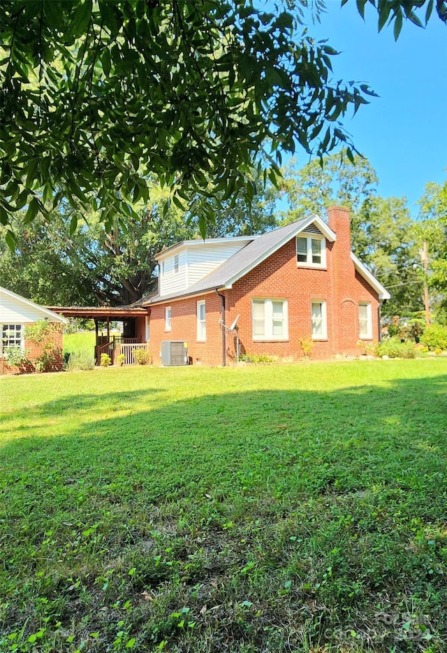 exterior space featuring a front lawn and central AC