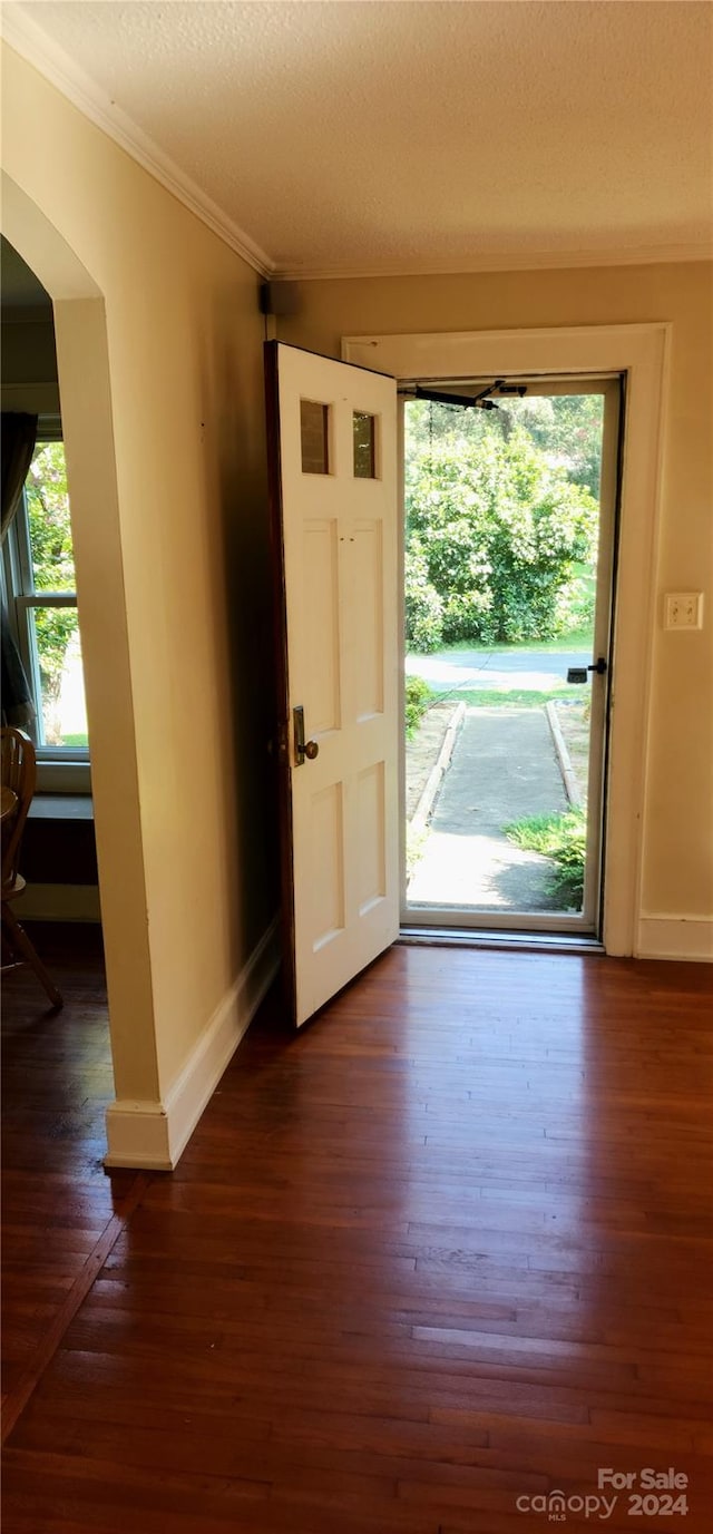 entryway featuring a textured ceiling, ornamental molding, and dark hardwood / wood-style flooring