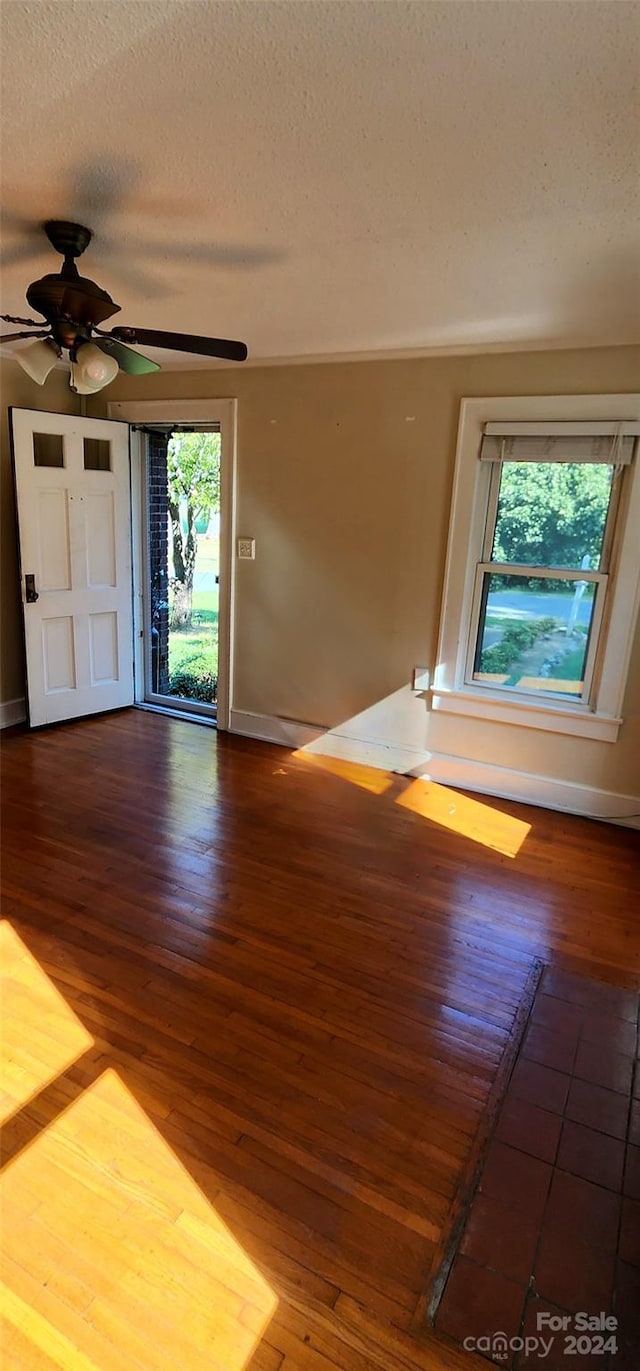 spare room with hardwood / wood-style floors, ceiling fan, and a textured ceiling