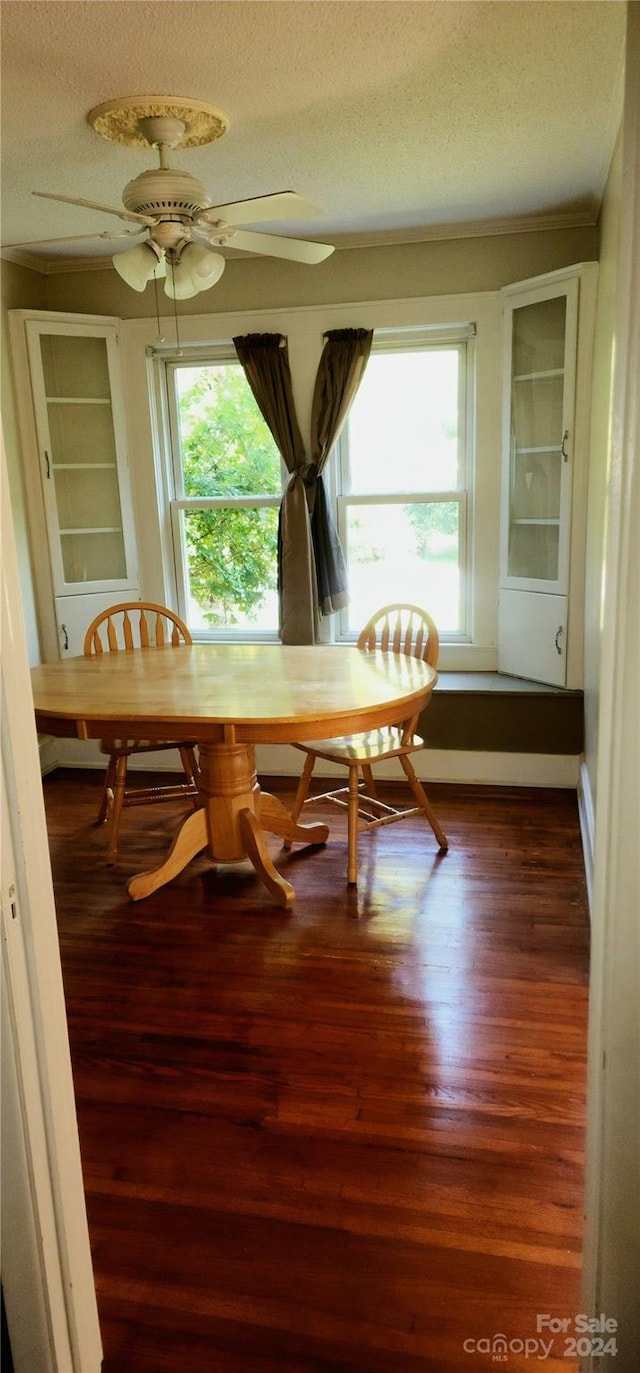 dining room featuring a textured ceiling, wood-type flooring, and ceiling fan