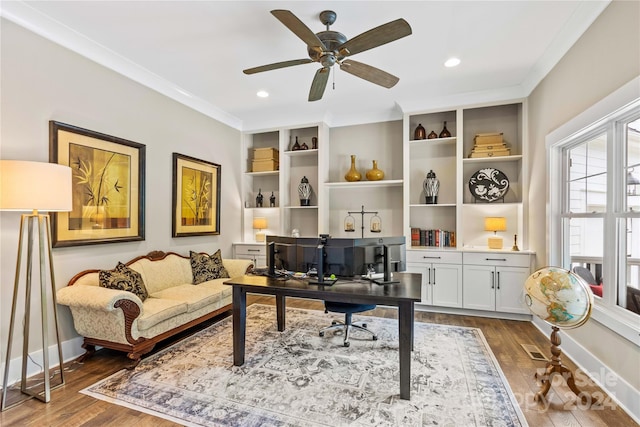 home office with built in features, hardwood / wood-style flooring, crown molding, and ceiling fan