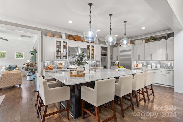 kitchen featuring dark wood-type flooring, decorative backsplash, a kitchen breakfast bar, and a spacious island