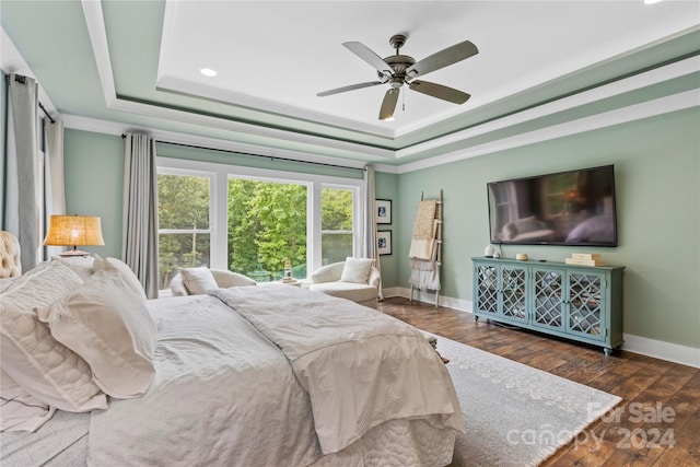 bedroom featuring dark hardwood / wood-style floors, ceiling fan, and a raised ceiling