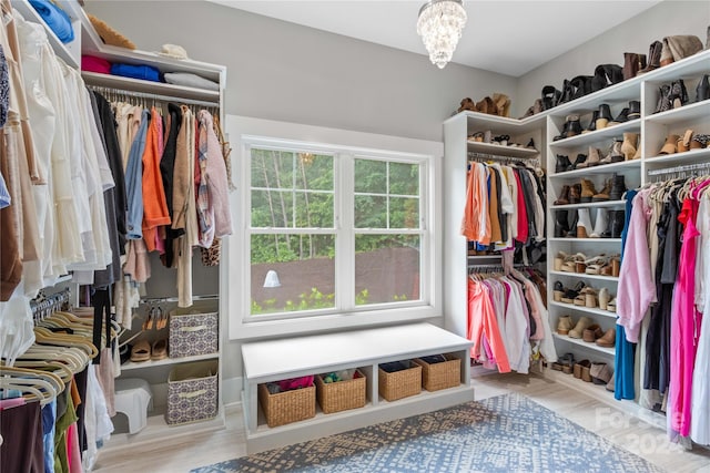 spacious closet featuring a notable chandelier and light wood-type flooring