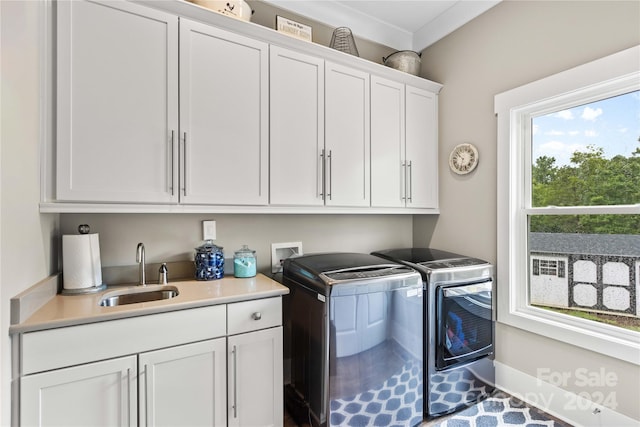 laundry room featuring cabinets, washer and clothes dryer, and sink