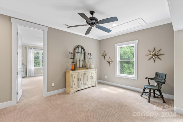 sitting room with light carpet, crown molding, and ceiling fan