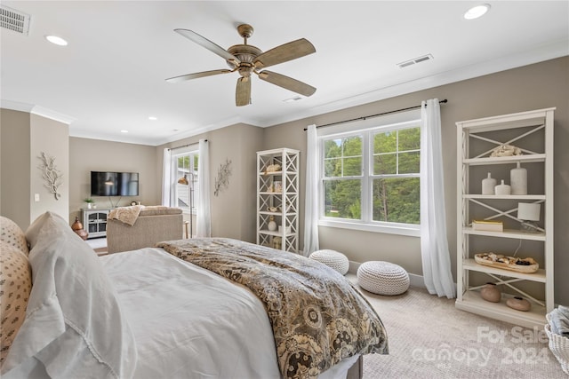 carpeted bedroom with ornamental molding and ceiling fan