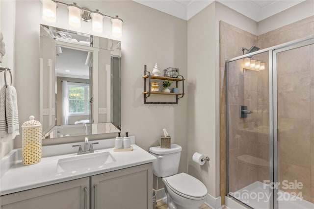 bathroom with a shower with shower door, vanity, and toilet