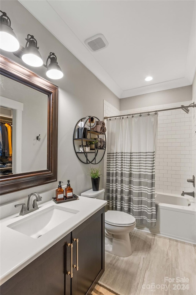 full bathroom with hardwood / wood-style floors, vanity, shower / bath combo, and toilet