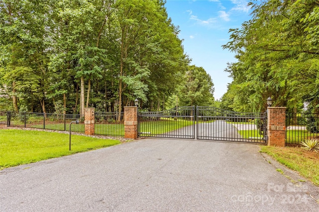 view of gate with a lawn