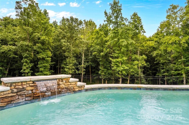 127 Tradition Ln, Mooresville, NC 28115 - view of swimming pool featuring a fenced in pool, fence, and a wooded view
