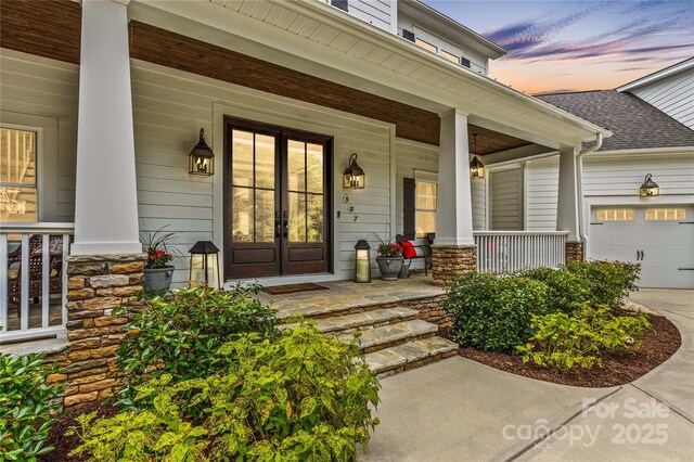 127 Tradition Ln, Mooresville, NC 28115 - entrance to property with covered porch, concrete driveway, stone siding, and a garage