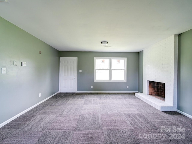 unfurnished living room with carpet and a brick fireplace