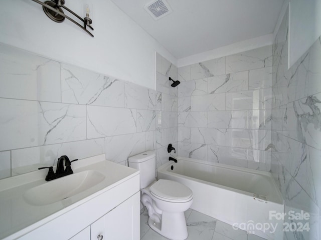 full bathroom with vanity, tiled shower / bath, tile walls, and toilet