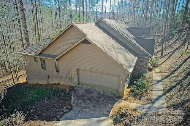 view of side of home with a garage and aphalt driveway