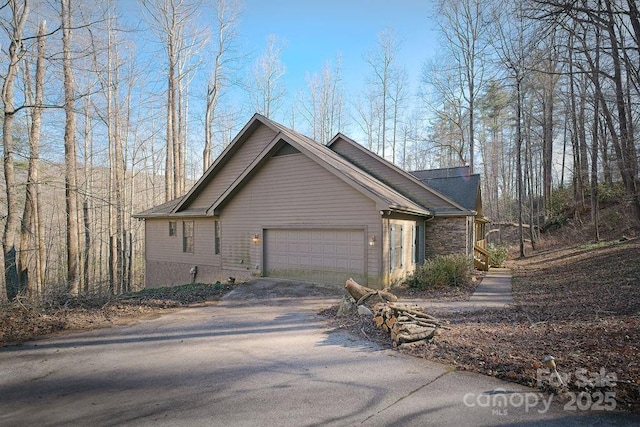 view of side of property with driveway and an attached garage