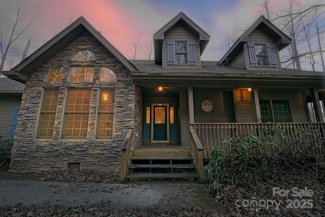 view of front of house featuring stone siding, a porch, and crawl space