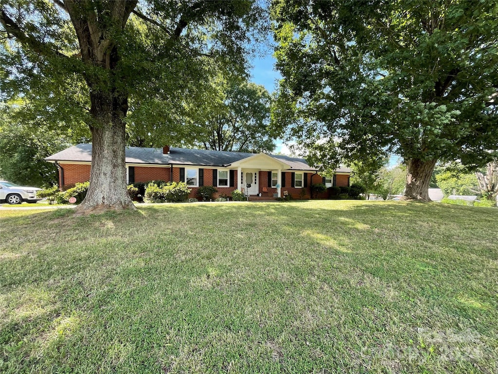 single story home featuring brick siding and a front yard