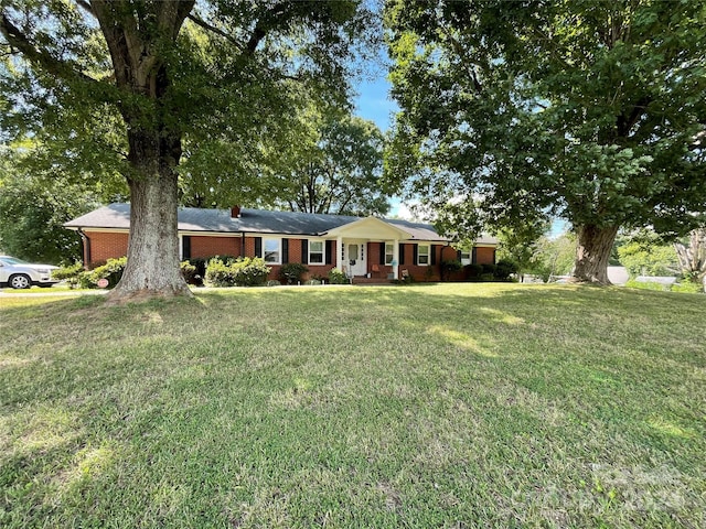 single story home featuring brick siding and a front yard