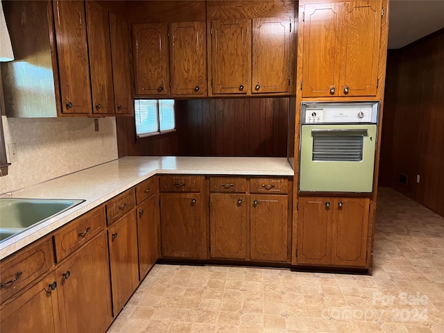 kitchen with oven and wooden walls