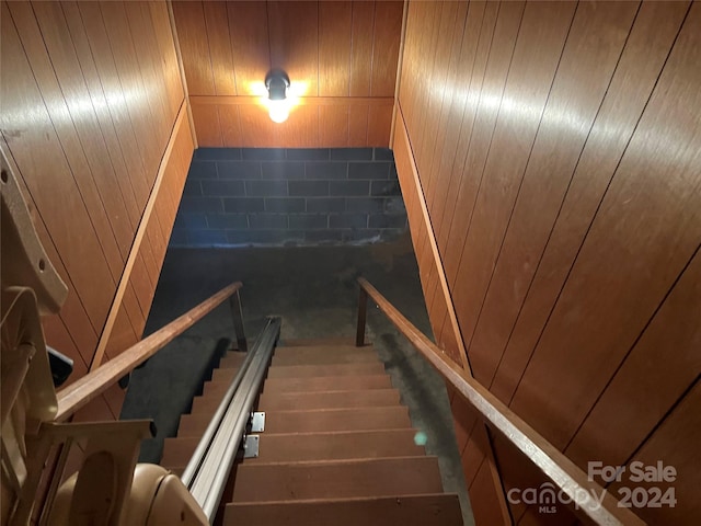 stairway featuring wood walls and hardwood / wood-style floors