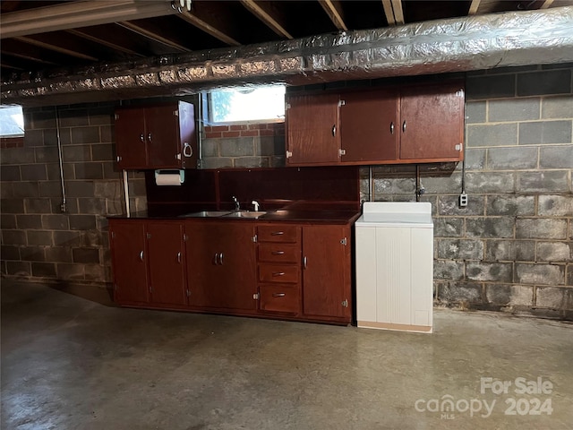 basement featuring sink and washer / dryer