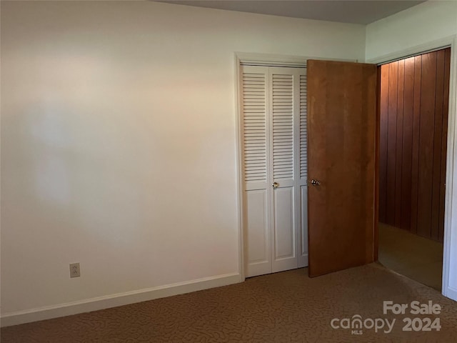 unfurnished bedroom with a closet and carpet flooring