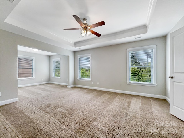 unfurnished room featuring carpet, ceiling fan, and a tray ceiling